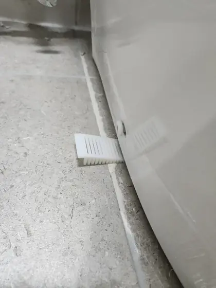 좌변기 흔들림 고정 — 밑동 틈에 끼운 흰 쐐기